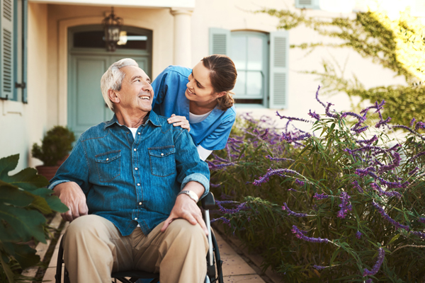 Caregiver with elderly man in wheelchair