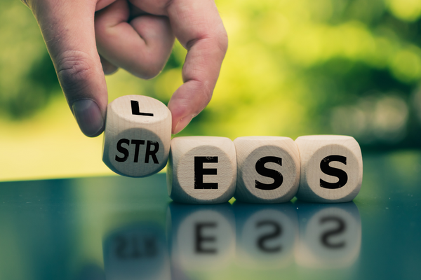 close up of a hand laying out letter blocks to spell "stress"