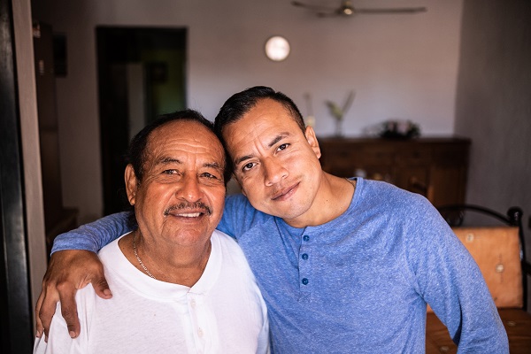 Portrait of Latin father and son at home